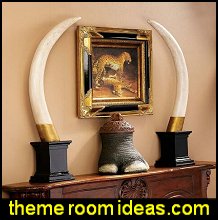 Add exotic interest to any room with these authentic replica big-game trophies. At nearly a yard tall atop its faux marble plinth, our more humane version of the British Colonial big game hunter�s prize is almost as large as the original! Beautiful as art alone, this naturalistic decorative element is cast in quality designer resin and realistically hand-painted in faux ivory and brass. A single tusk is striking on a console in a safari themed bedroom or animal safari themed office. Jungle and safari theme room decor.